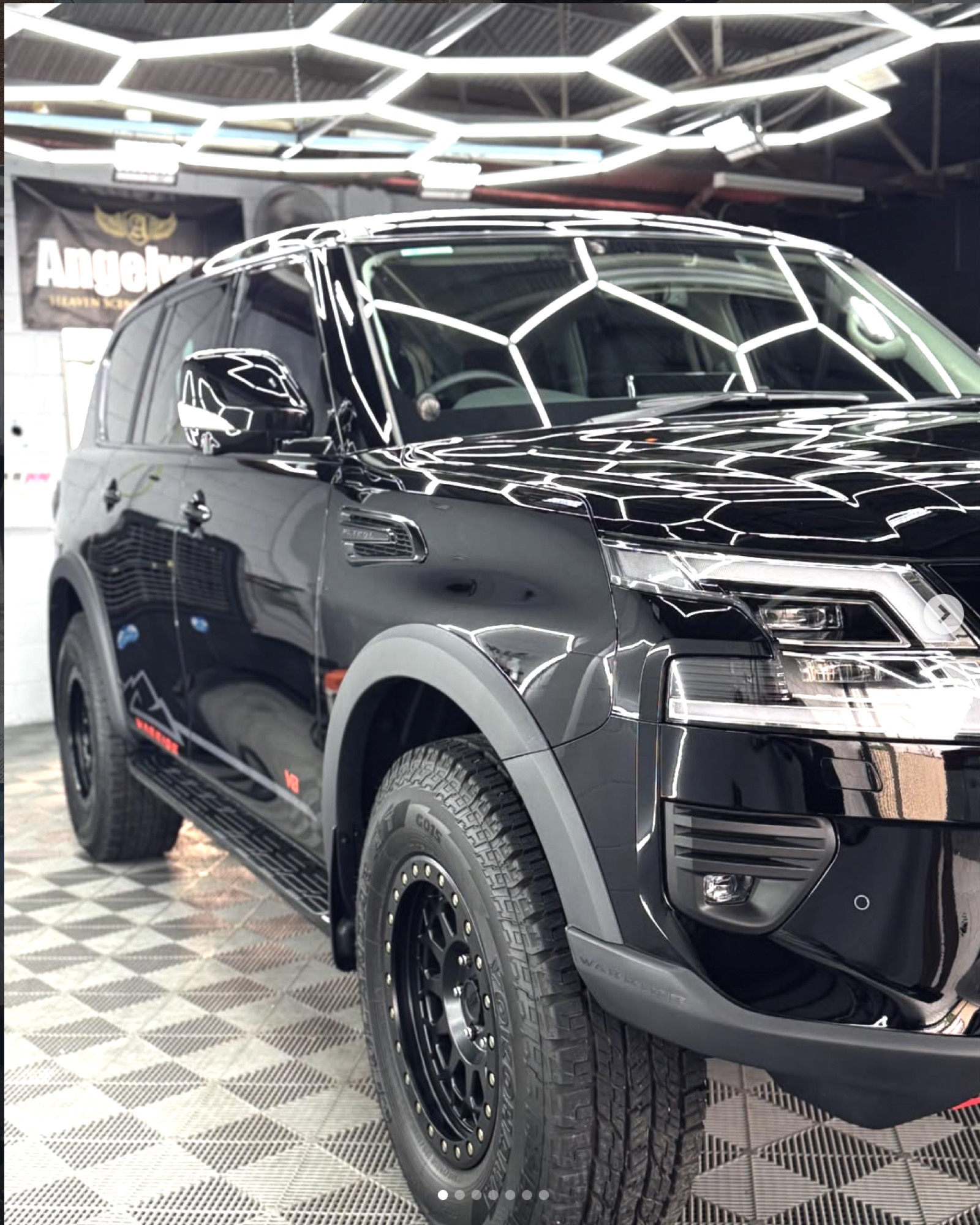 Black Nissan Patrol Warrior freshly detailed under hexagonal studio lighting at TB Detailing Mount Isa
